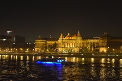 a boat in the water in front of a large building