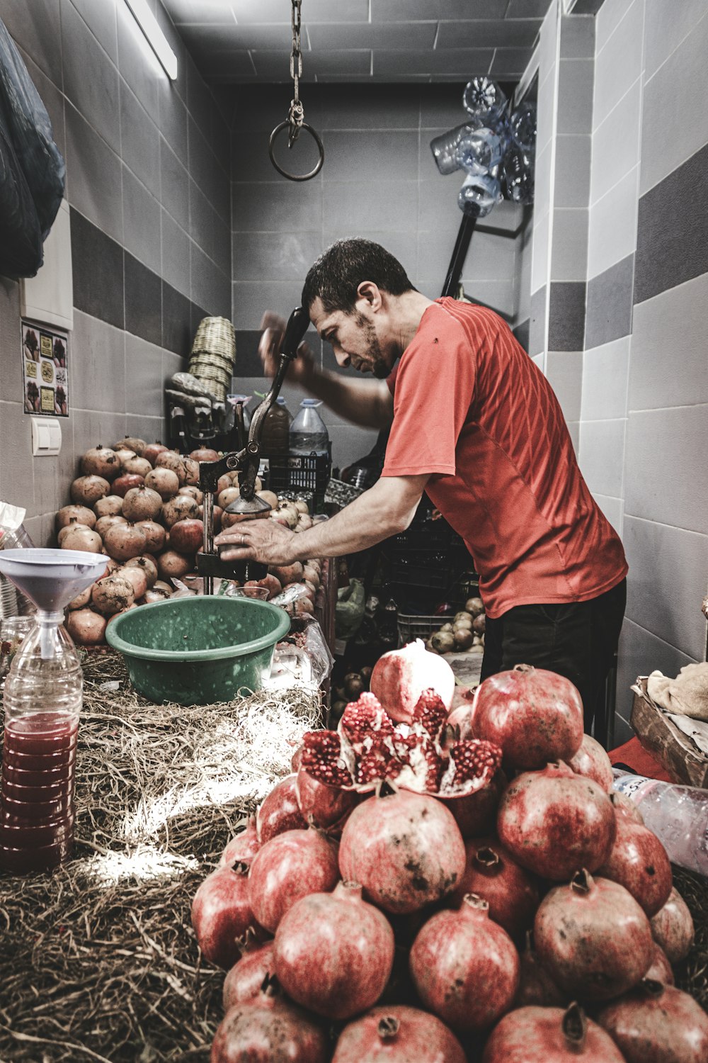 a man standing over a pile of pomegranates