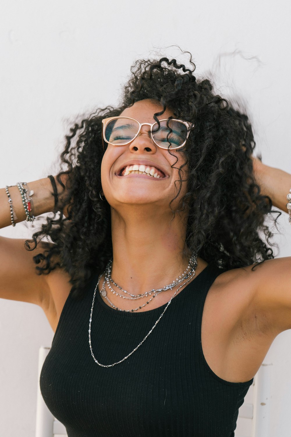 a woman wearing glasses and a black tank top