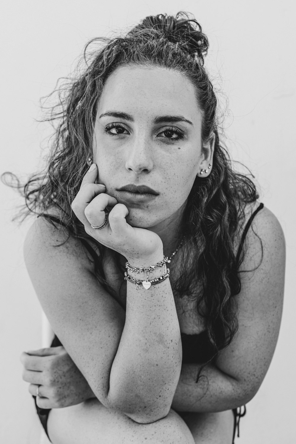 a black and white photo of a woman with her hand on her chin