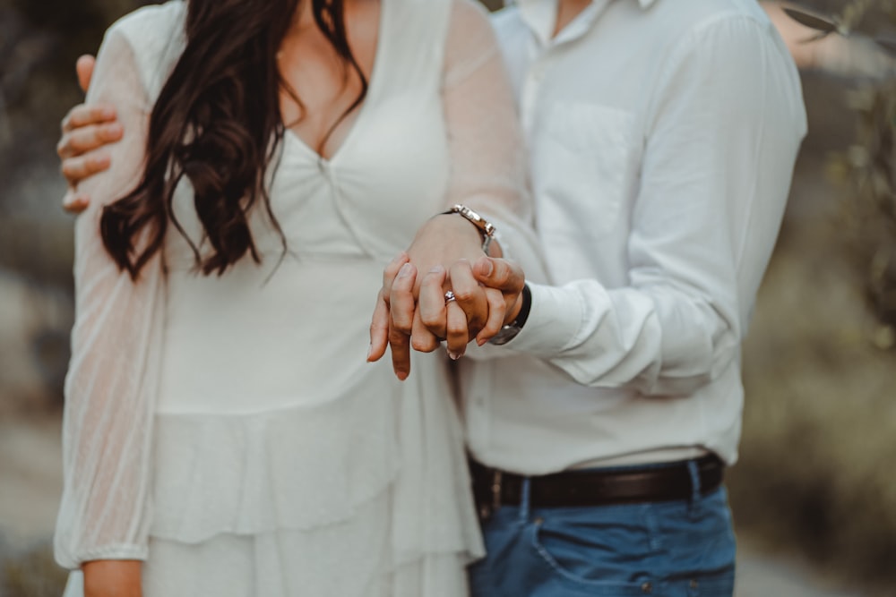 a man and a woman holding hands while standing next to each other