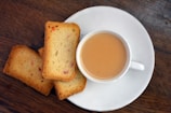 a white plate topped with slices of bread next to a cup of tea