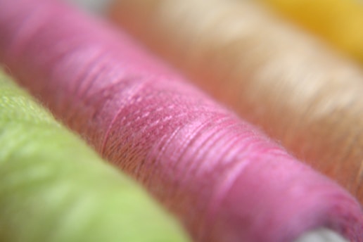 A close-up of vibrant threads and fabric pieces ready for sewing.