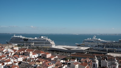 Scenic coastal landscape with cruise ships docked near a vibrant port city.