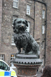 a statue of a dog on a pedestal in front of a building