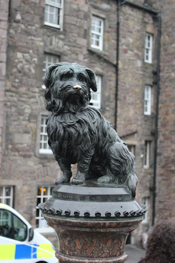 a statue of a dog on a pedestal in front of a building