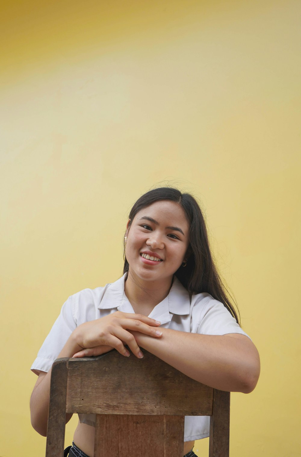 a girl sitting on a chair smiling for the camera