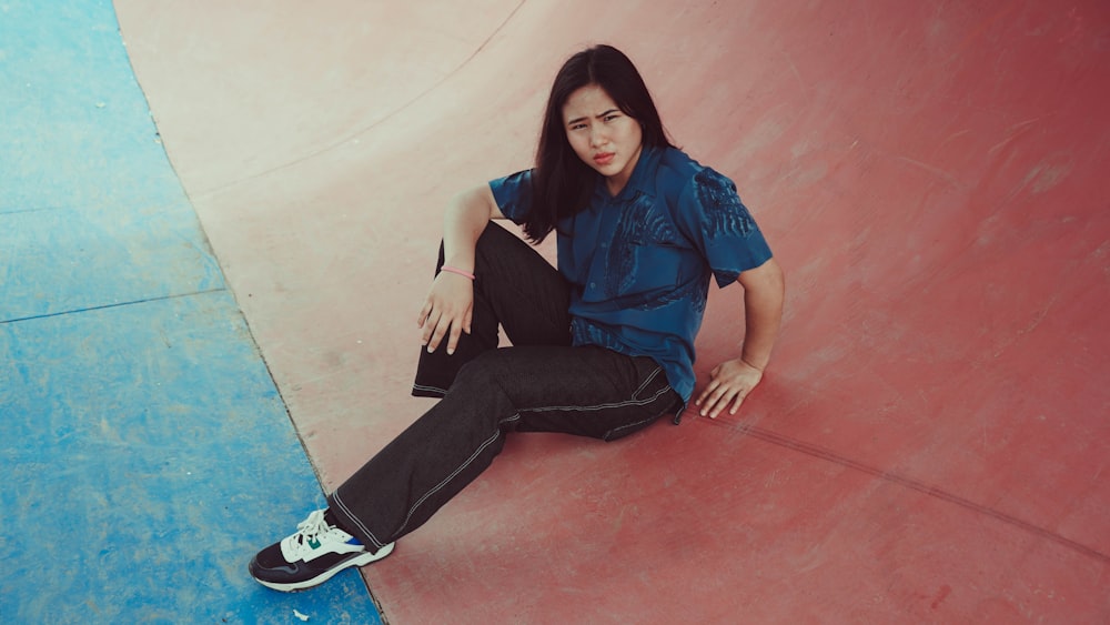 a woman sitting on a skateboard in a skate park