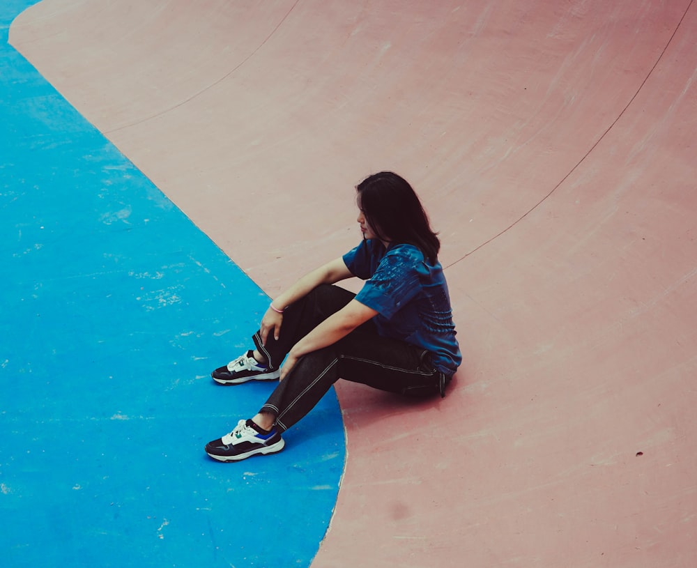 a person sitting on a skateboard in a skate park