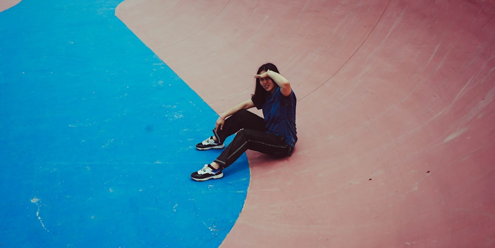 a person sitting on a skateboard in a skate park