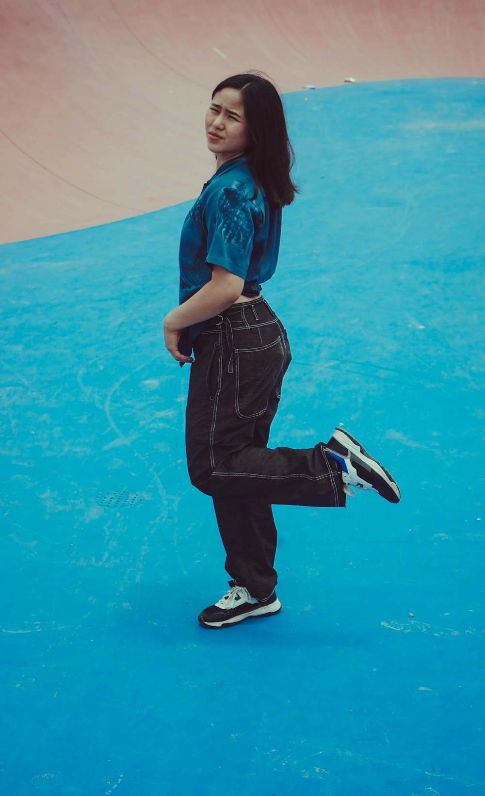 a young girl is standing on a blue surface