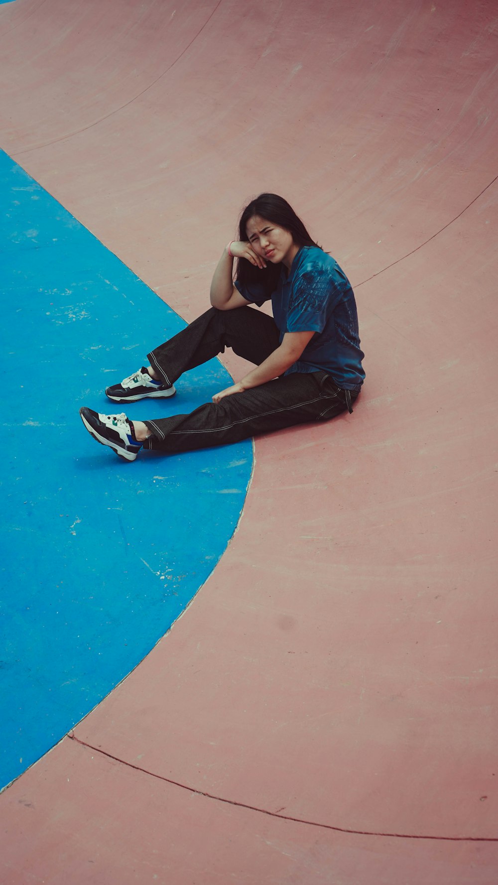 a person sitting on a skateboard in a skate park