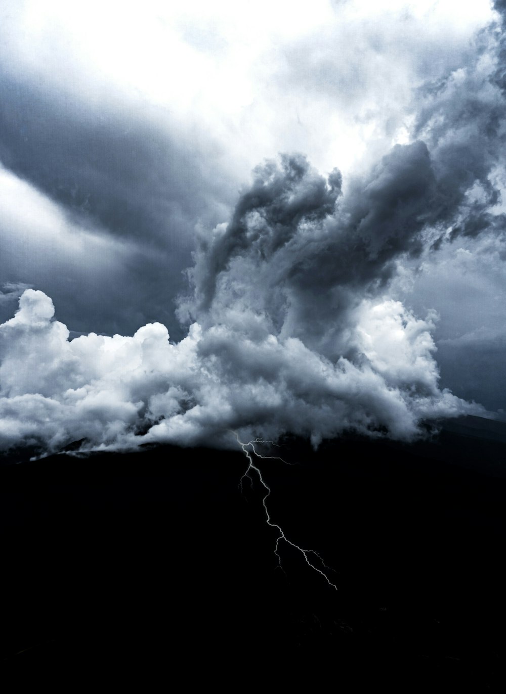 a large cloud with a lightning bolt in the middle of it