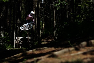 Dynamic shot of a cyclist geared up with ankle supports and protective cycling set on a sunny trail.