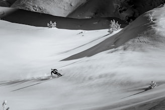 a man riding skis down a snow covered slope