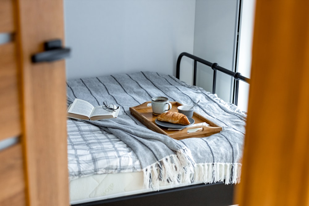 a bed with a tray of food on top of it