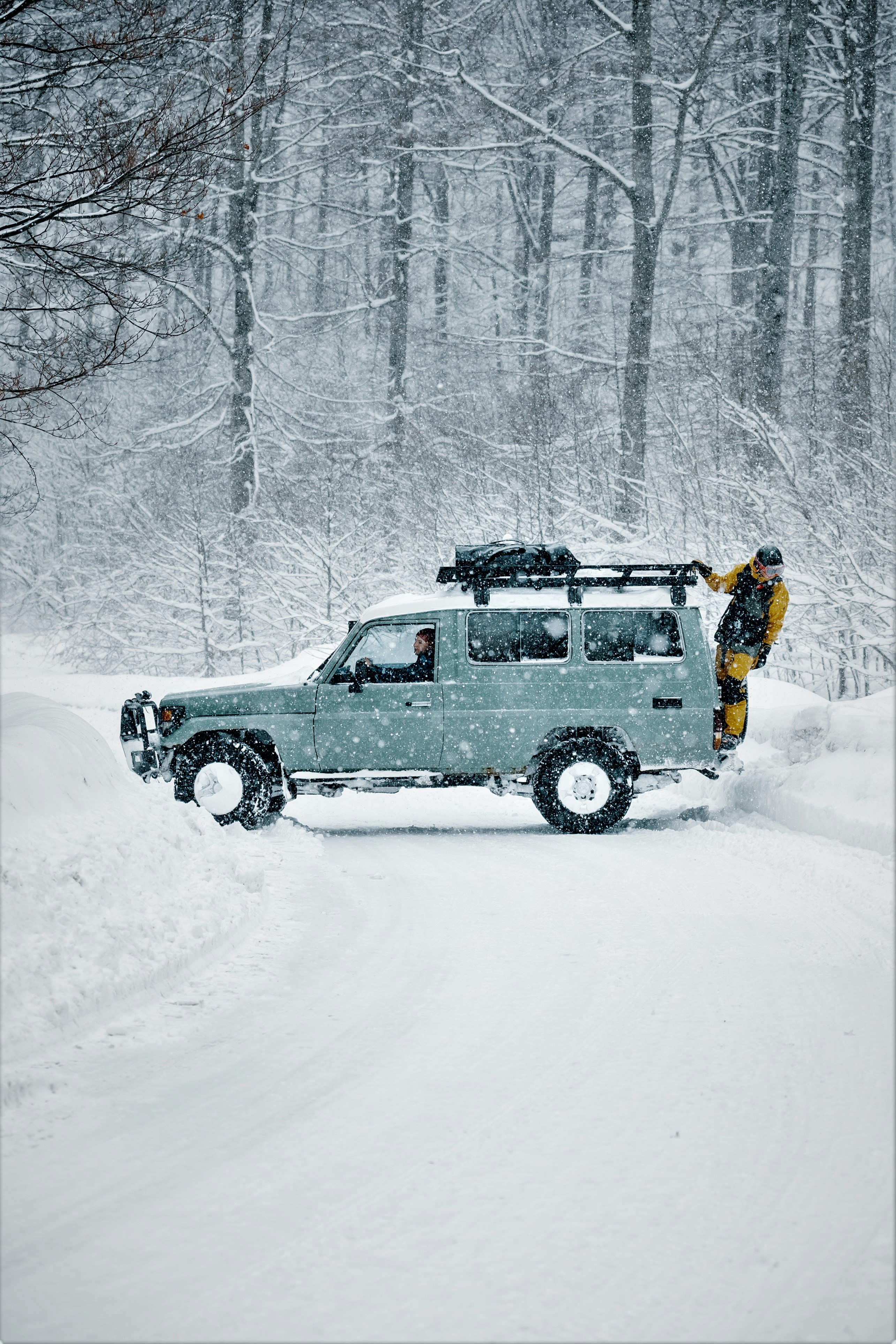 a man standing on top of a truck in the snow