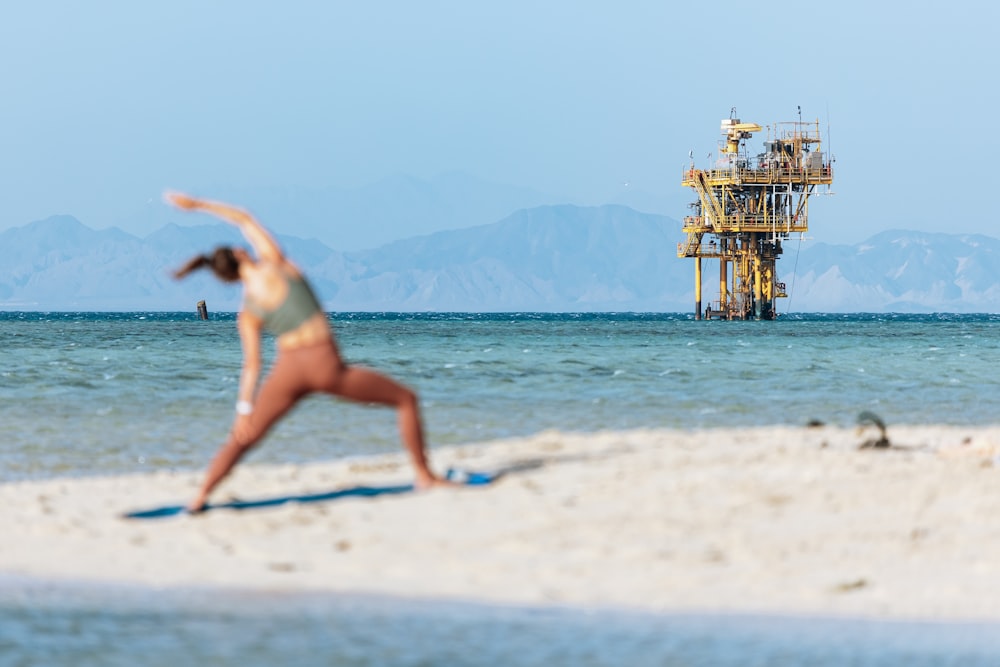 a woman in a bikini doing yoga on the beach