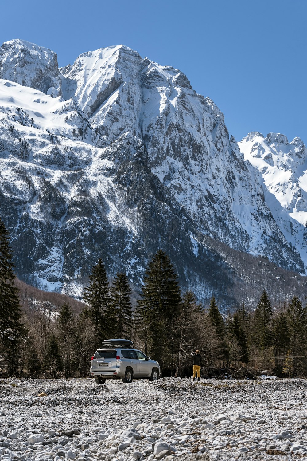 a car is parked in front of a snowy mountain