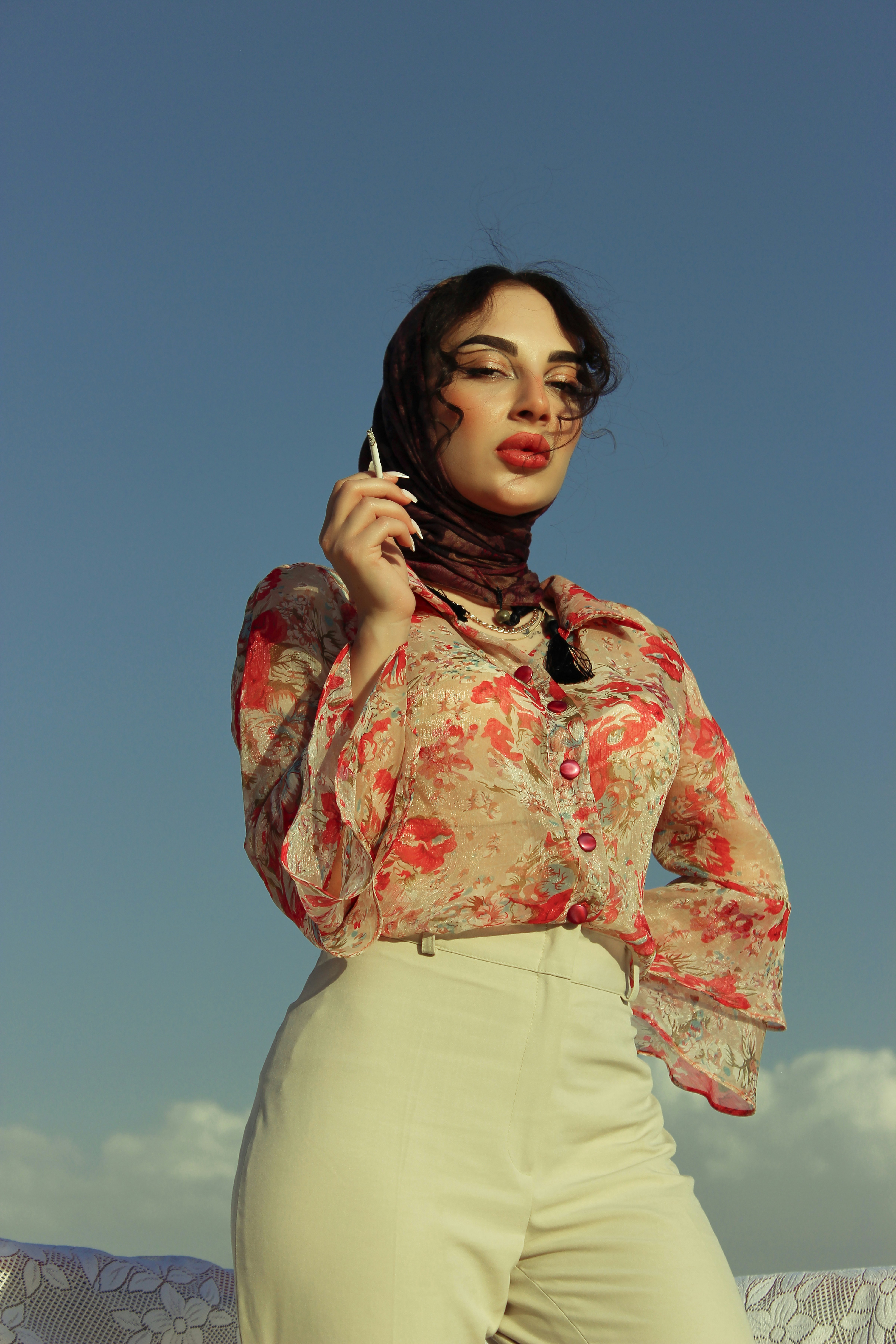 a woman in a floral shirt is holding a cell phone
