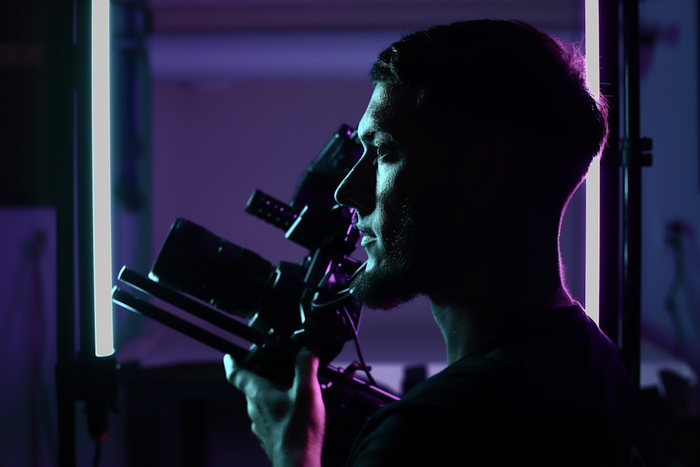 a man holding a camera in a dark room