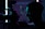 A silhouetted profile of a person holding a professional camera, illuminated by contrasting blue and purple lights, creating a dramatic and artistic atmosphere.
