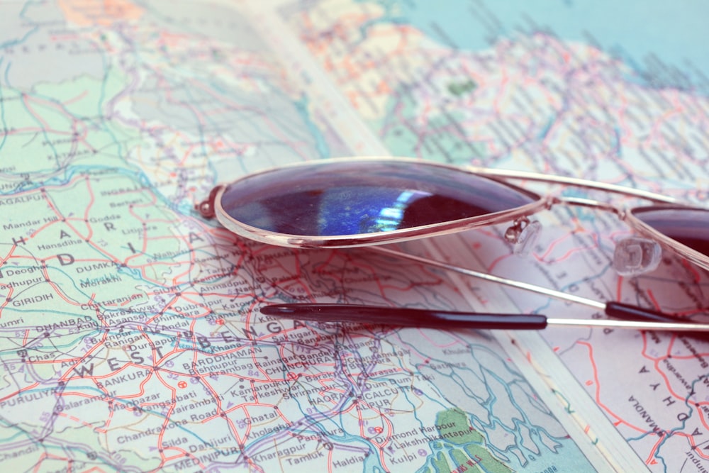a pair of sunglasses sitting on top of a map