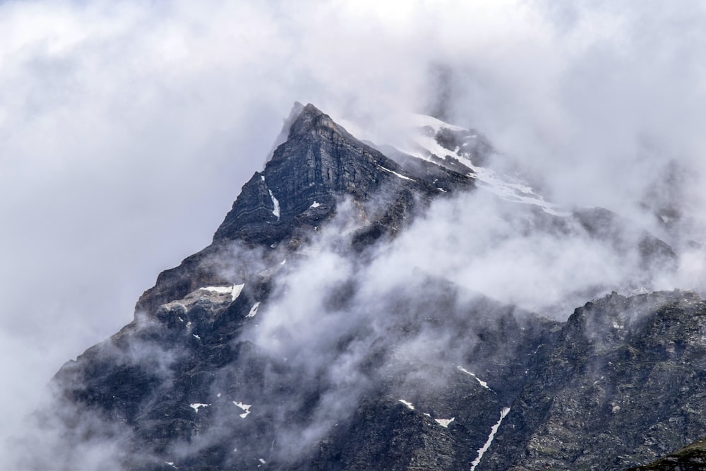 una montagna molto alta coperta di neve e nuvole