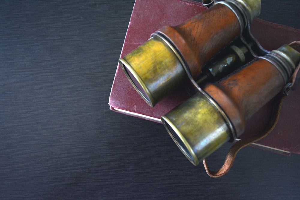 a pair of binoculars sitting on top of a red book