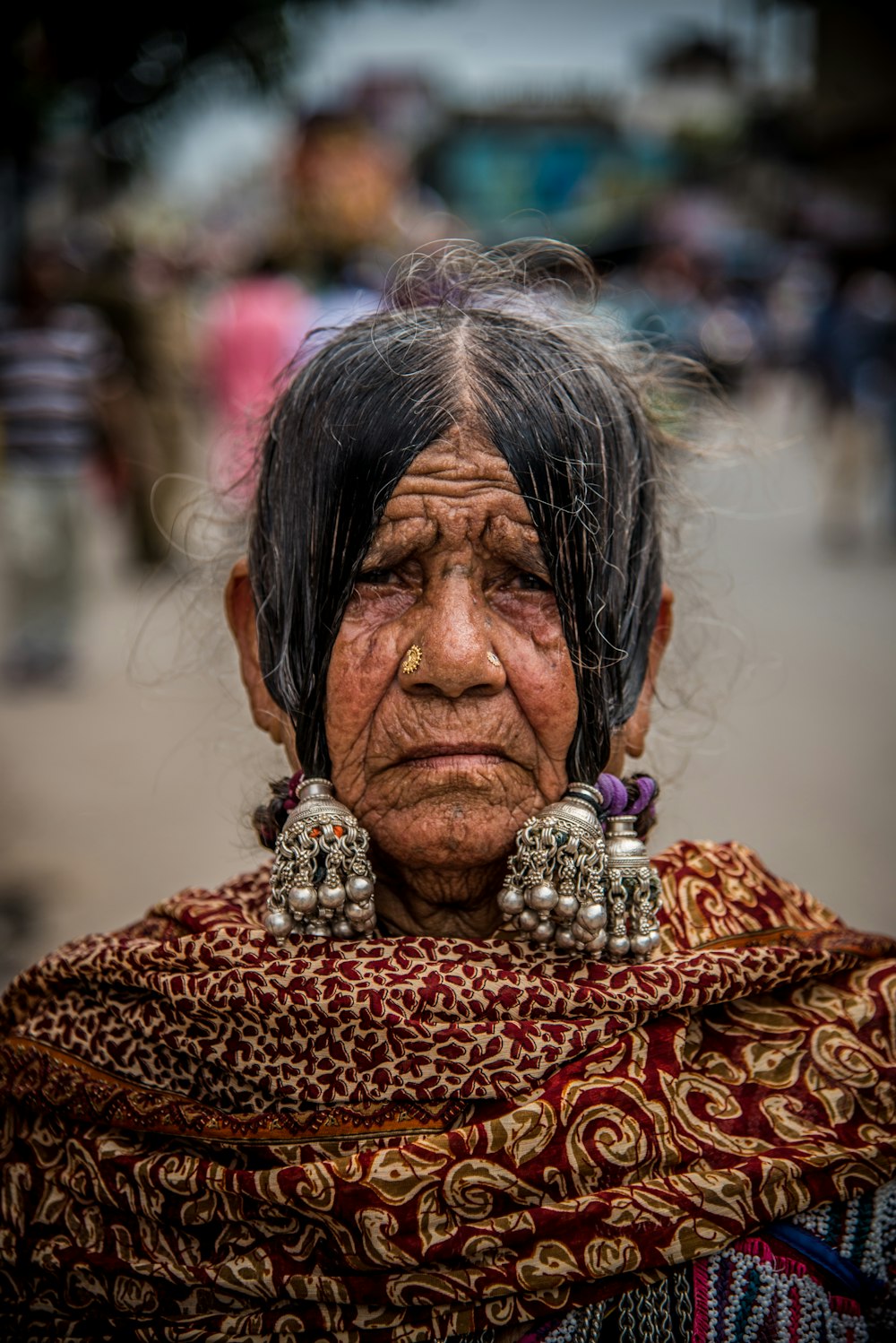 an old woman with earrings on her head