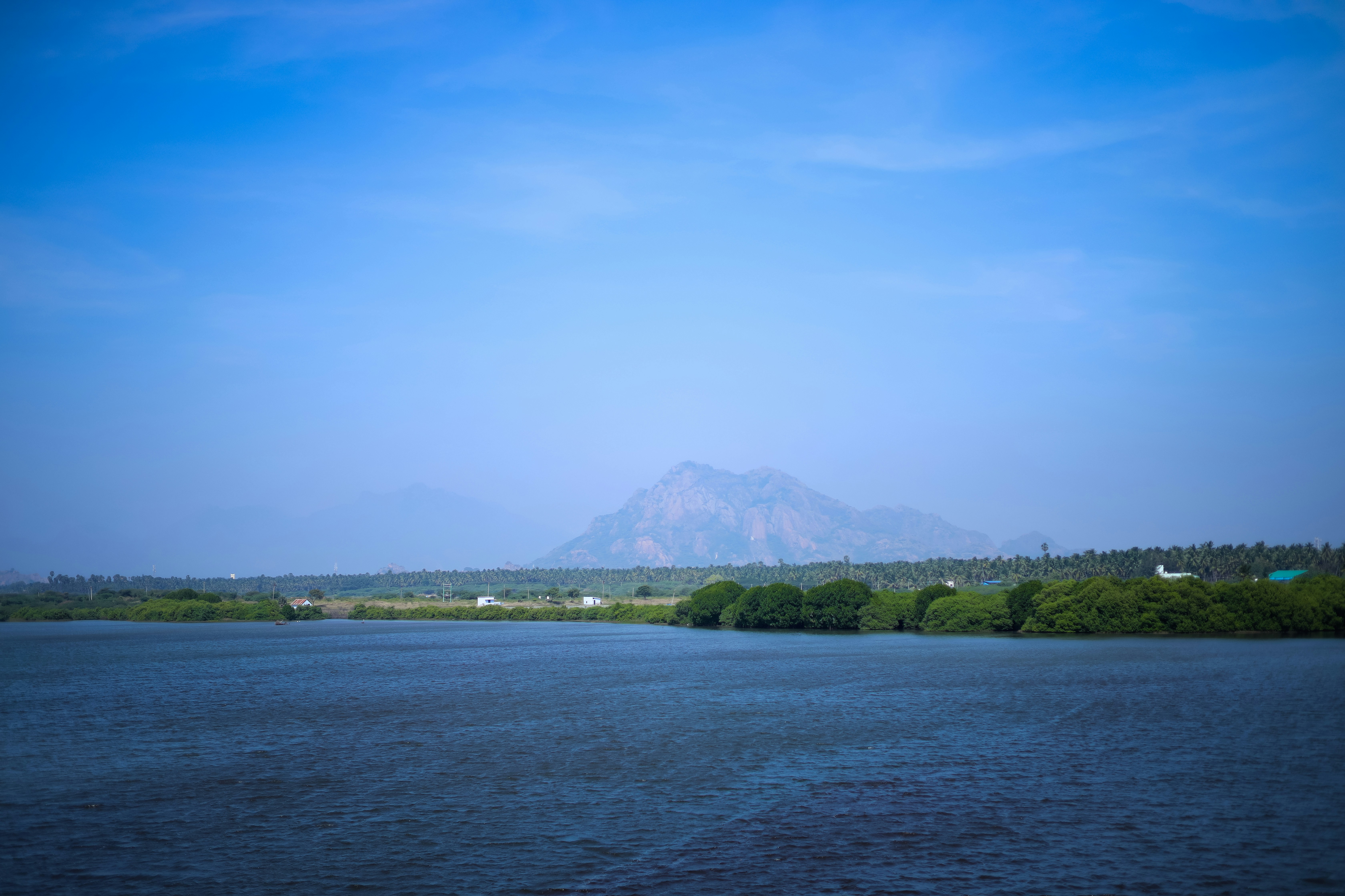 a large body of water with a mountain in the background