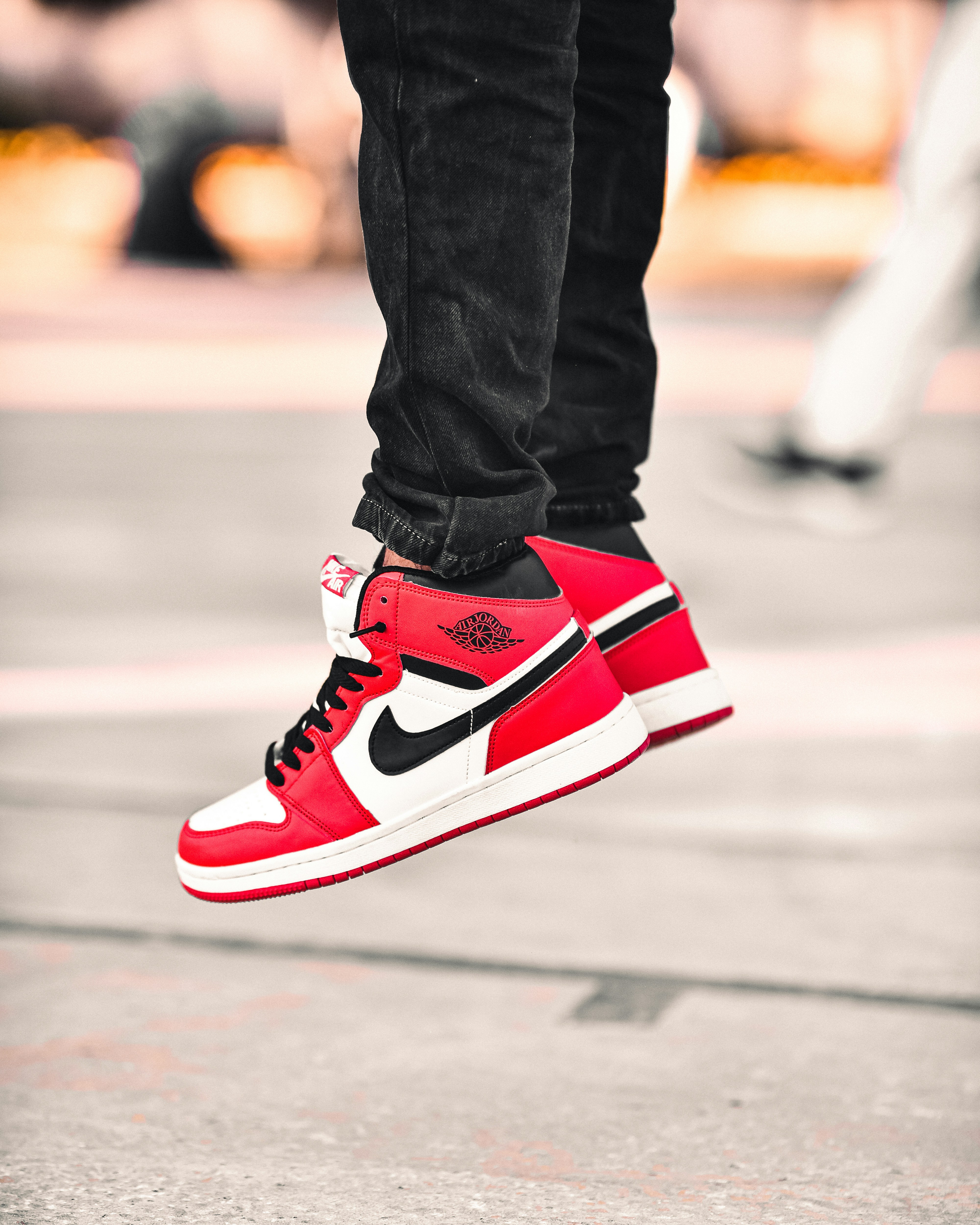 une personne portant des baskets rouges et noires sautant en l’air