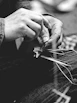 Close-up of a master artisan hand-knotting a silk Afghan rug with delicate precision.
