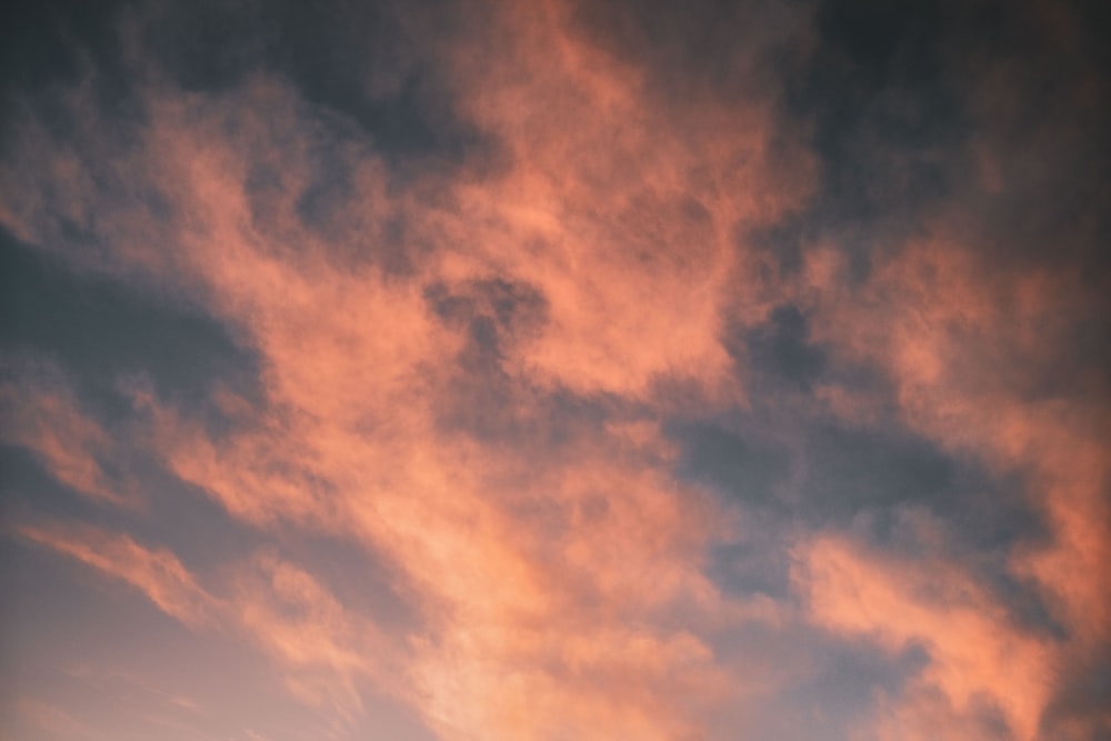 a plane flying in the sky at sunset