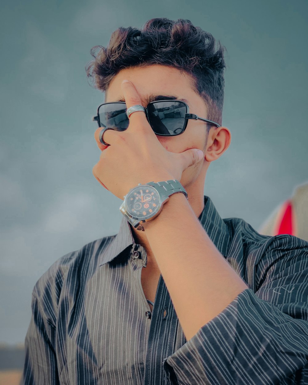 a man wearing sunglasses and a watch on his wrist