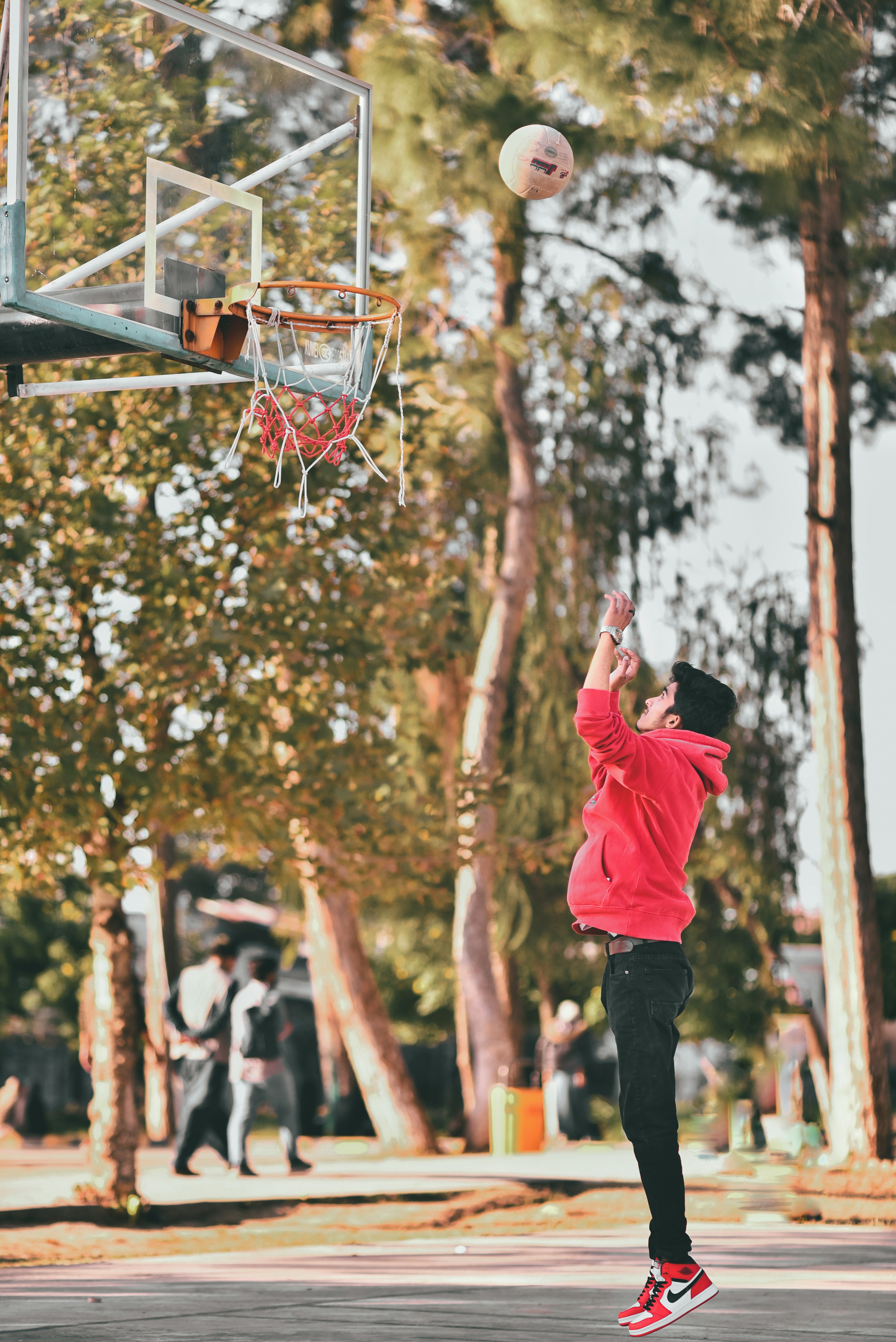 Un homme en veste rouge joue au basketball