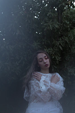 A serene moment of a woman meditating outdoors, surrounded by greenery and calm.