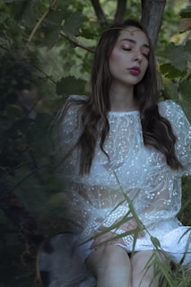 A serene outdoor setting with a woman in a flowing dress, embracing nature.