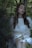 A serene outdoor scene featuring a model wearing a flowing, sustainable dress in nature.