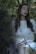A serene outdoor scene featuring a model wearing a flowing, sustainable dress in nature.