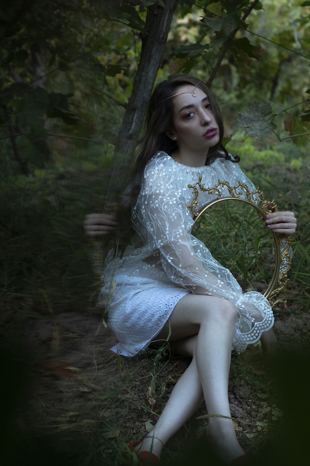 a woman in a white dress holding a mirror