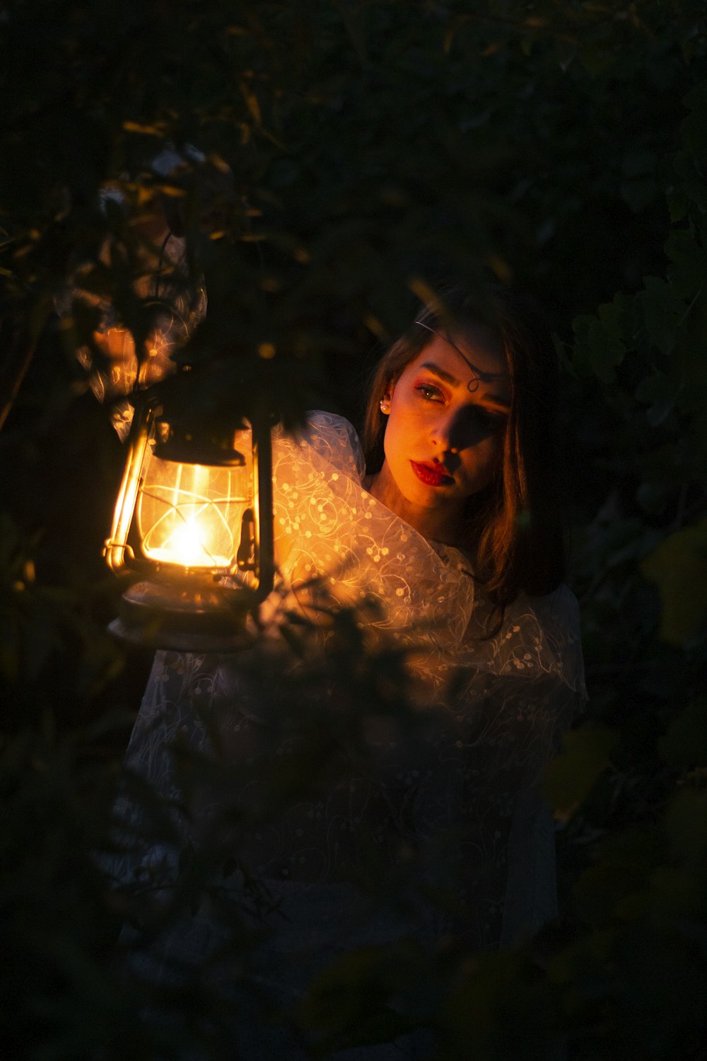 uma mulher segurando uma lanterna no escuro