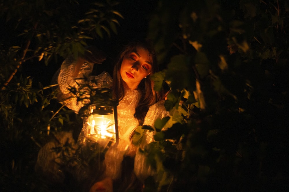 a woman holding a lantern in the dark