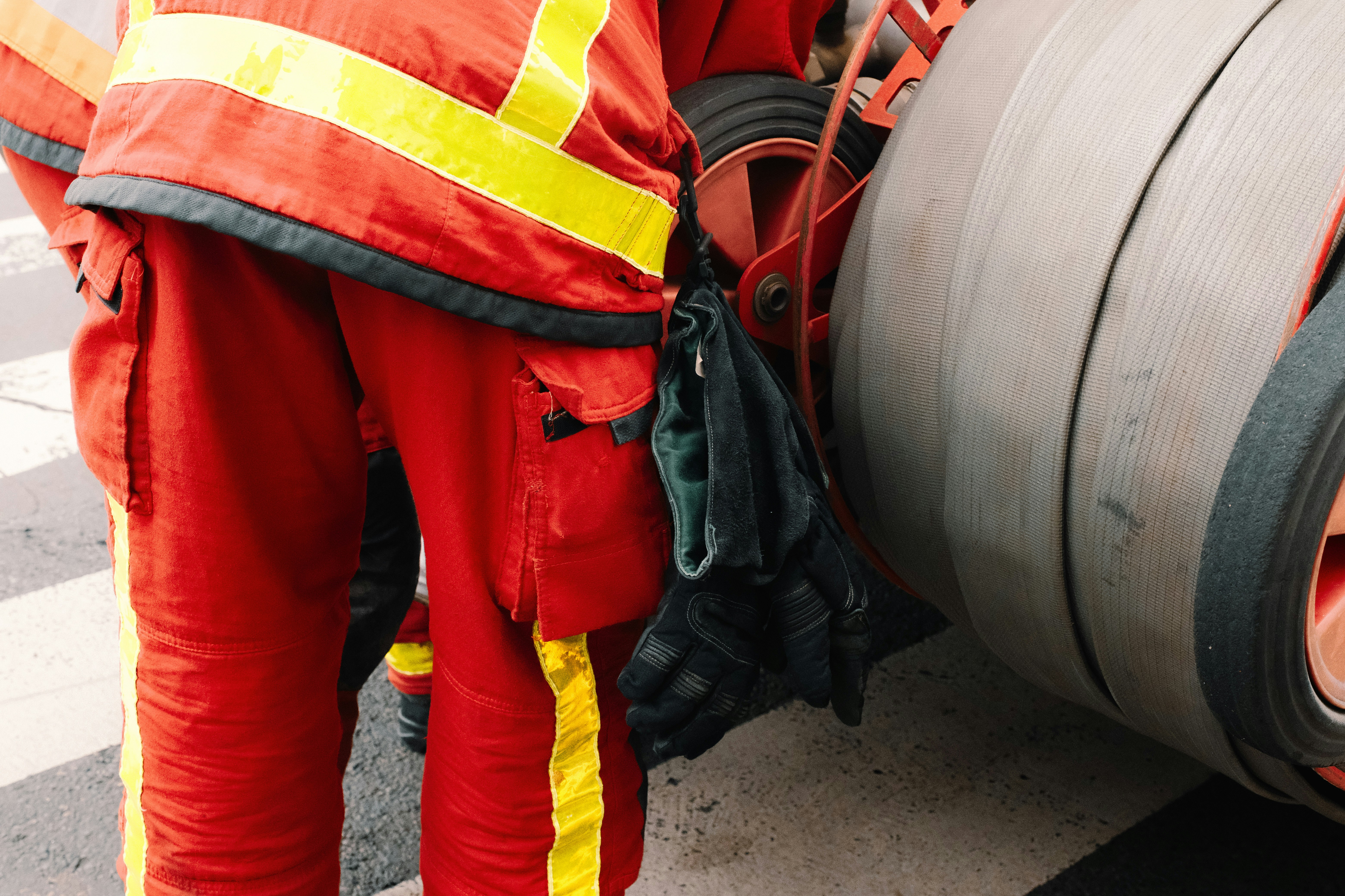 a man in safety gear standing next to a large tire