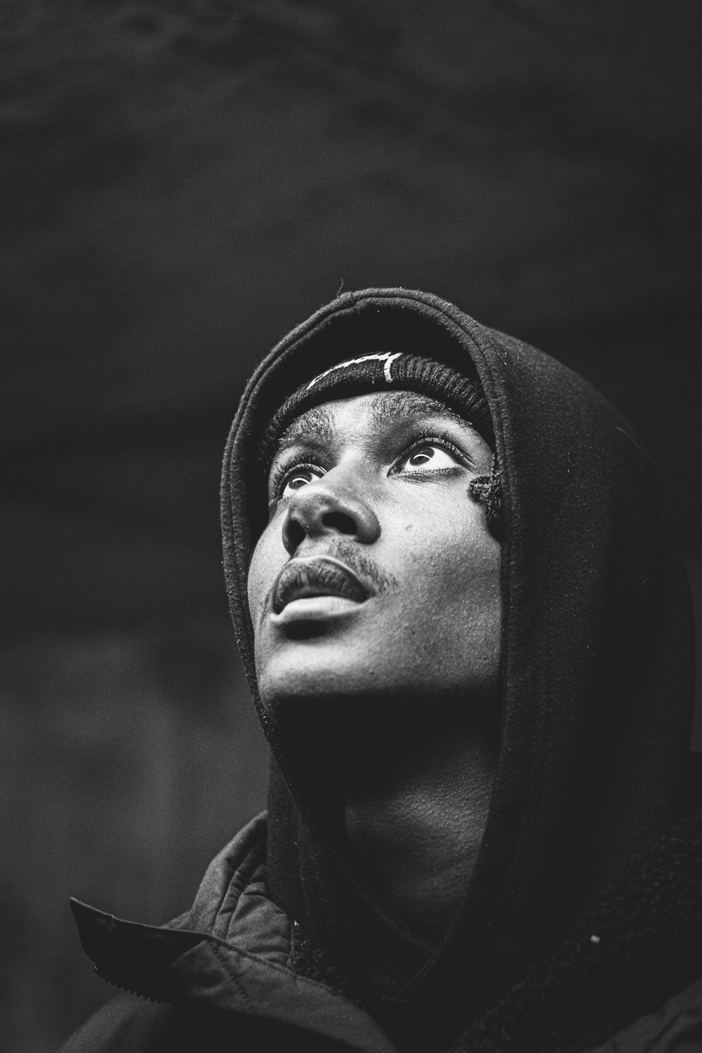 a black and white photo of a person wearing a hoodie
