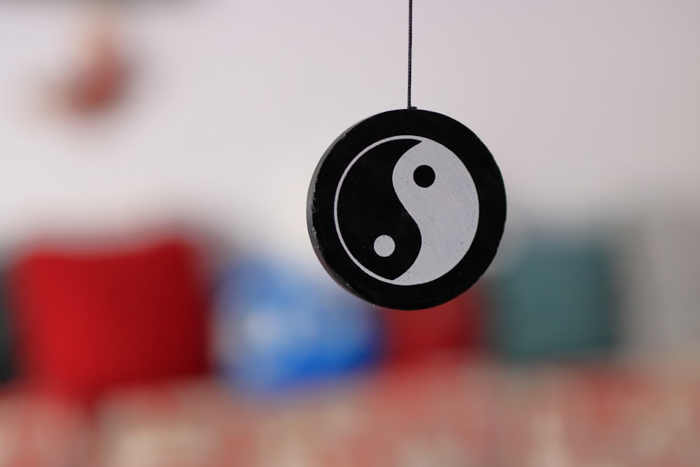 a black and white yin sign hanging from a string