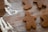 Several gingerbread cookies in the shape of people are placed on a wooden surface, lightly dusted with flour.