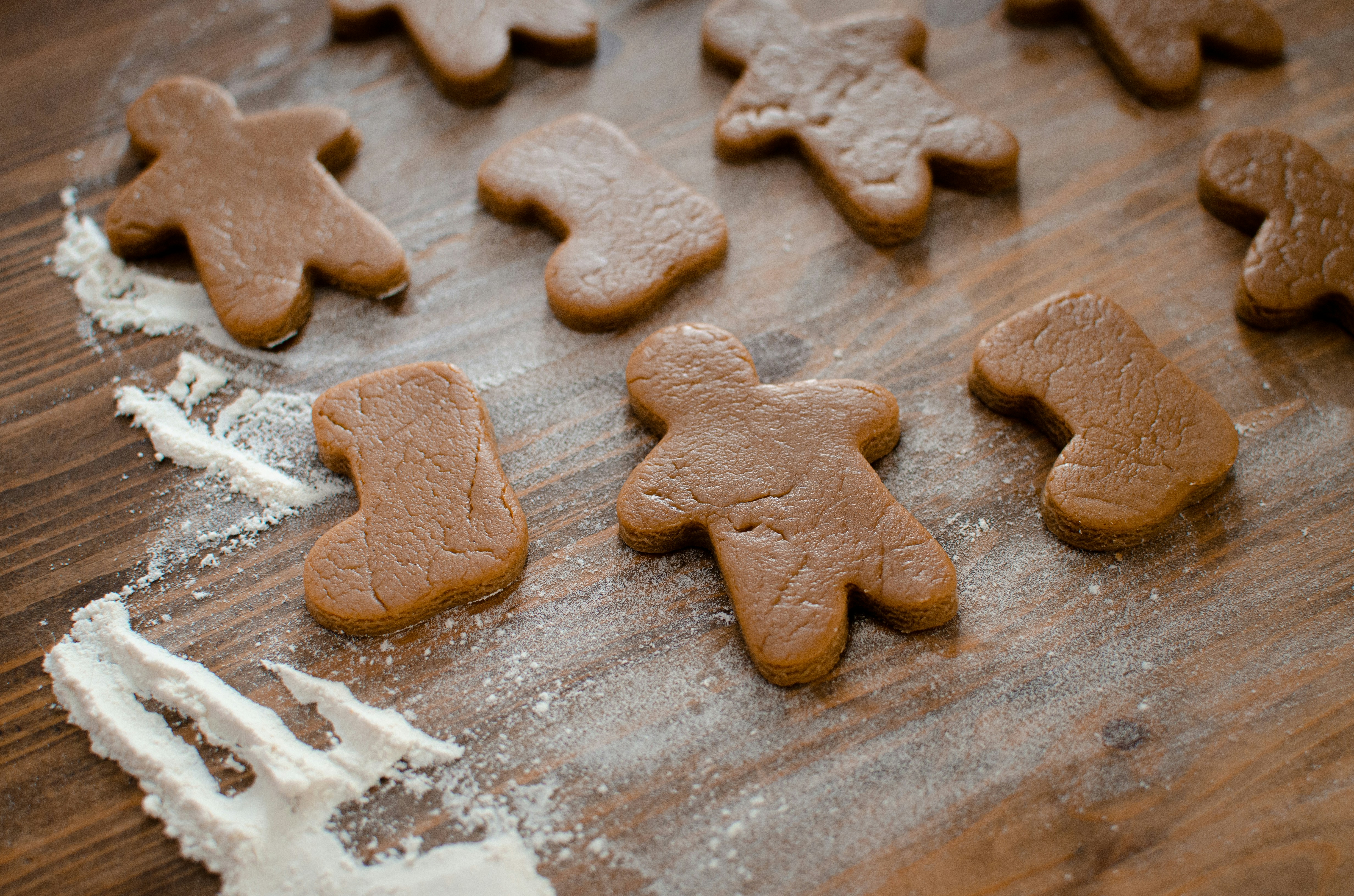 a wooden table topped with lots of cut out cookies