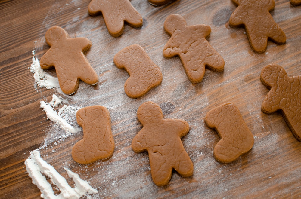 a wooden table topped with lots of cut out cookies