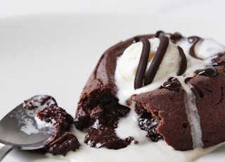 a white plate topped with a piece of cake and ice cream